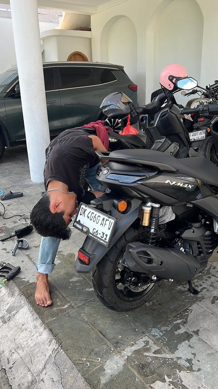 SparkWash technician detailing a Yamaha NMAX scooter in Bali